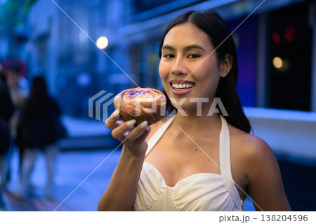 Thai Woman Holding Egg Tart on Hong Kong Street Thai Woman Holding Egg Tart on Hong Kong Street 138204596