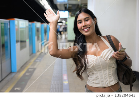 Thai Woman Waving on Hong Kong Subway Station Platform with Phone Thai Woman Waving on Hong Kong Subway Station Platform with Phone 138204643