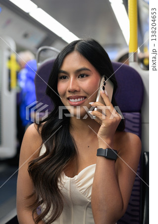 Asian Woman Talking on Smartphone in Hong Kong Train 138204653