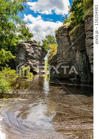 Canyon between which flows a river against the blue sky and green trees Canyon between which flows a river against the blue sky and green trees 138204983