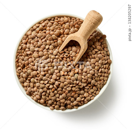Bowl of brown lentils with wooden spoon isolated on white background, top view 138205297