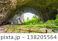 Devetashka Cave Entrance with Visitor Hut and Green Meadow 138205564