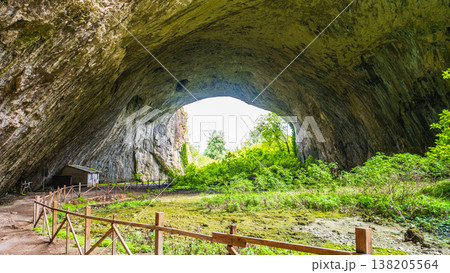 Devetashka Cave Entrance with Visitor Hut and Green Meadow Devetashka Cave Entrance with Visitor Hut and Green Meadow 138205564