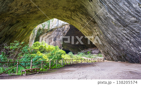 Devetashka Cave Interior with Wooden Fence and Bench on Dirt Path Devetashka Cave Interior with Wooden Fence and Bench on Dirt Path 138205574