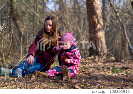 Young mother and her daughter are relaxing in a spring forest park 138205919