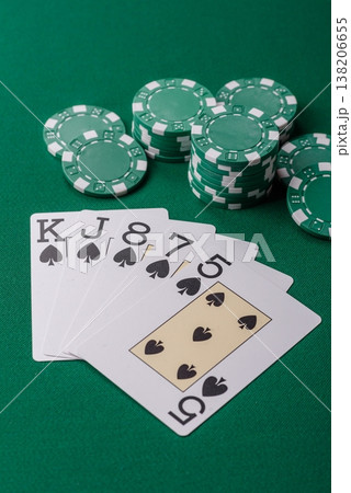 Playing cards and chips on a green cloth, a gambling game of poker. Cards and chips Playing cards and chips on a green cloth, a gambling game of poker. Cards and chips 138206655