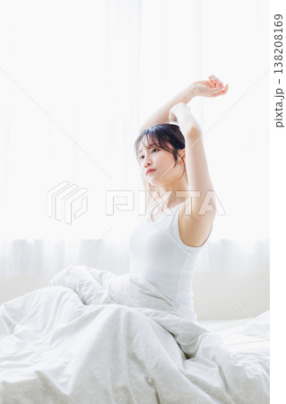 朝の寝室で伸びをする若い女性 朝の寝室で伸びをする若い女性 138208169