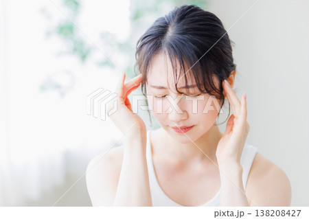 寝起きに気分が優れない女性  頭痛  体調不良 138208427