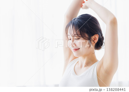 朝の寝室で伸びをする若い女性 138208441