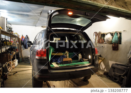 The Volkswagen car is in the garage with an open trunk. The Volkswagen car is in the garage with an open trunk. 138208777