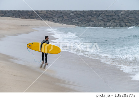 Surfer with board under his arm Surfer with board under his arm 138208778