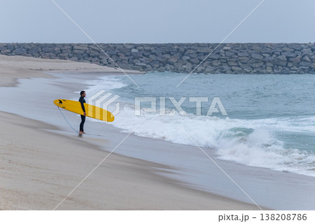 Surfer with board under his arm 138208786