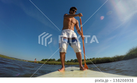 Man stand up paddleboarding Man stand up paddleboarding 138208938