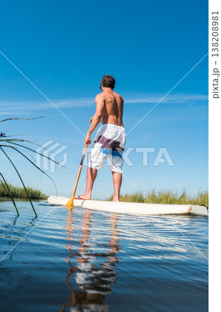 Man stand up paddleboarding Man stand up paddleboarding 138208981