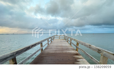 Empty wooden pier with dramatic sky and calm water Empty wooden pier with dramatic sky and calm water 138209059