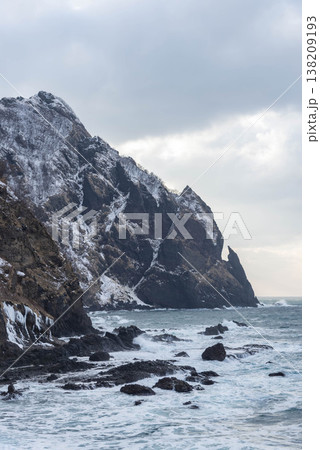 冬の北海道雷電海岸の兜岩。雪を被った断崖絶壁と波打つ海の風景 冬の北海道雷電海岸の兜岩。雪を被った断崖絶壁と波打つ海の風景 138209193