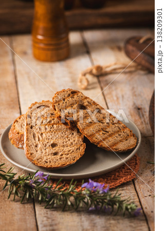 Toasted Sourdough Bread Slices on a Gray Plate with Rosemary 138209301
