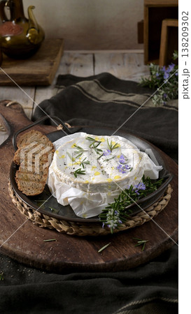Baked Camembert Cheese with Rosemary and Toasted Bread on Rustic Wooden Board 138209302