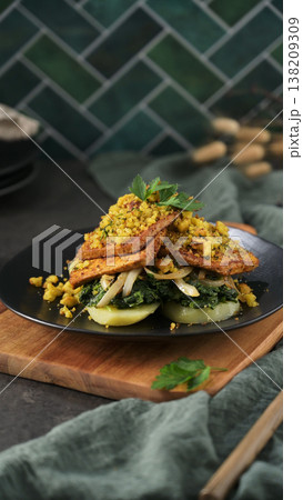 Seared Tofu with Sauteed Greens and Crumbled Topping on a Dark Plate Seared Tofu with Sauteed Greens and Crumbled Topping on a Dark Plate 138209309
