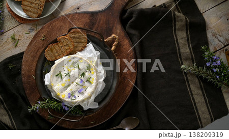 Baked Camembert Cheese with Rosemary and Garlic on a Rustic Wooden Platter Baked Camembert Cheese with Rosemary and Garlic on a Rustic Wooden Platter 138209319