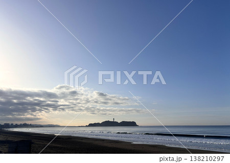 朝の光に照らされた白い雲と海と灯台のある島 138210297