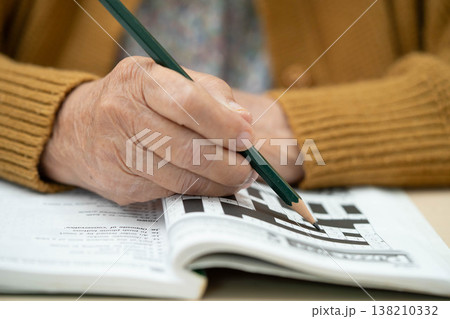 Bangkok, Thailand - May 15, 2022 elderly woman playing sudoku puzzle game. 138210332