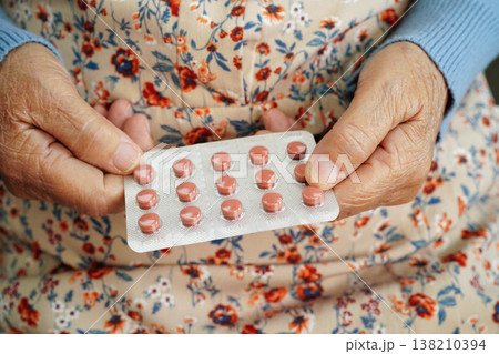 Asian elderly woman holding pill drug in hand, strong healthy medical. Asian elderly woman holding pill drug in hand, strong healthy medical. 138210394