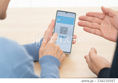 スマホアプリの使い方の説明を受けるシニア女性 138210587