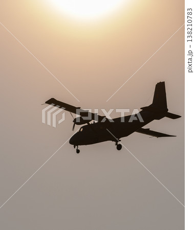 Aircraft flying in silhouette against a warm sunset sky, a dramatic aviation scene during an aerial flight demonstration Aircraft flying in silhouette against a warm sunset sky, a dramatic aviation scene during an aerial flight demonstration 138210783