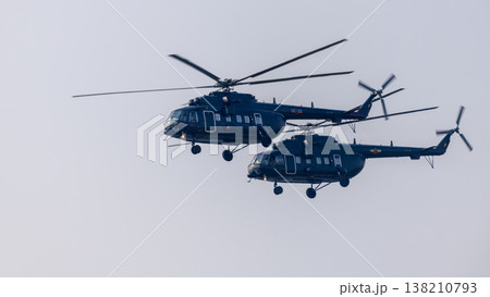 Two helicopters flying in close formation against a clear sky background. Coordinated aerial aviation transport and rotorcraft flight show Two helicopters flying in close formation against a clear sky background. Coordinated aerial aviation transport and rotorcraft flight show 138210793