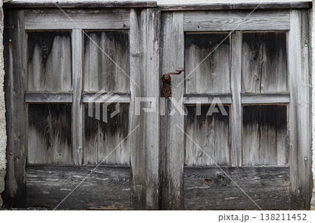 Weathered wooden double gate with rusty handle 138211452