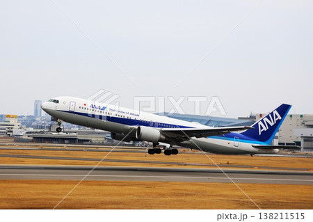 大阪・伊丹空港の滑走路から離陸していく全日本空輸の飛行機 138211515