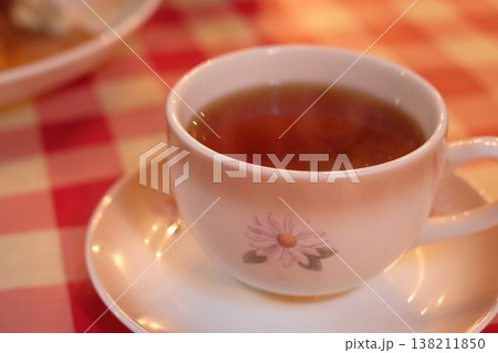 赤いブロックチェックのテーブルクロス上の紅茶 花柄カップ入りでカフェ風 赤いブロックチェックのテーブルクロス上の紅茶 花柄カップ入りでカフェ風 138211850
