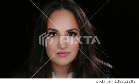 Empowerment and Confidence Portrait of a Young Woman with Dark Hair and Eyes Against a Dark Empowerment and Confidence Portrait of a Young Woman with Dark Hair and Eyes Against a Dark 138212108