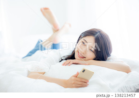 ベッドでスマホを見る女性 138213457