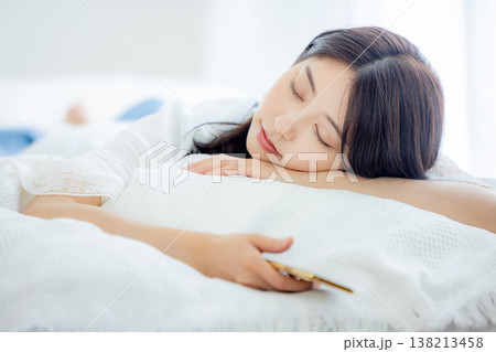 ベッドでスマホを見る女性 ベッドでスマホを見る女性 138213458