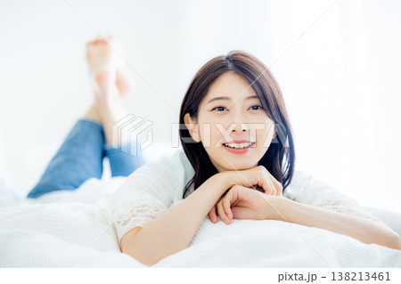 ベッドで寝転がる女性 138213461