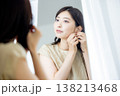 鏡を見て身支度する女性 138213468