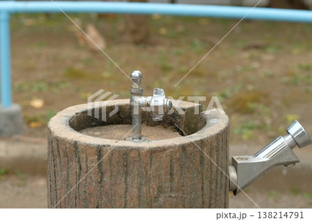 公園の丸太デザイン水飲み場 シルバーの蛇口をクローズアップ 公園の丸太デザイン水飲み場 シルバーの蛇口をクローズアップ 138214791