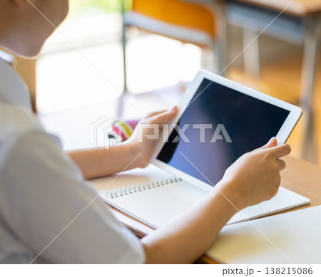 机でタブレットを持つ生徒の後ろ姿 机でタブレットを持つ生徒の後ろ姿 138215086