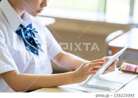 教室でタブレットを操作する女子生徒の横顔 138215093