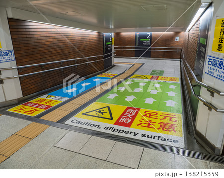 原宿駅構内の通路に設置された通行区分と足元注意の路面標示 138215359