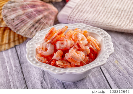 Cooked peeled shrimp in a ceramic bowl on a rustic gray wooden table with a seashell. Cooked peeled shrimp in a ceramic bowl on a rustic gray wooden table with a seashell. 138215642