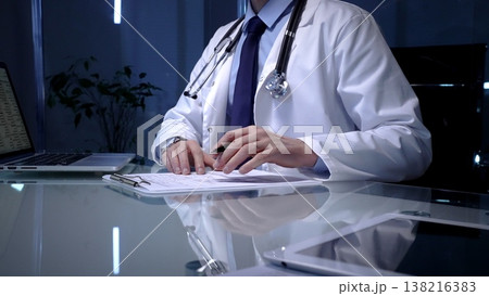 Doctor or health professional managing patient data, documenting information, and utilizing digital technology for medical records and administrative tasks in a clinic or office setting 138216383