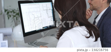 Architects collaborating on building plans using computer aided design software and architectural models. Business and architecture concept 138216756