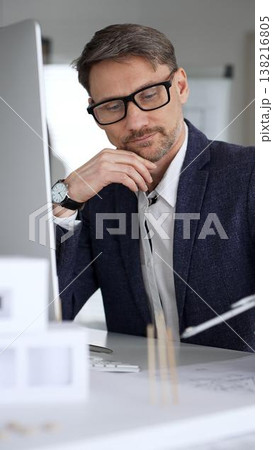 Architect man thinking while working on blueprints and computer, planning new building design in office. Business and architecture concept 138216805
