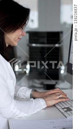 Architect women working at desktop computer, checking blueprints and design plans for a new engineering project. Business and architecture concept Architect women working at desktop computer, checking blueprints and design plans for a new engineering project. Business and architecture concept 138216837