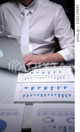 Businessman studying financial report data with laptop and charts, conducting detailed audit and analysis. Audit and taxes in business Businessman studying financial report data with laptop and charts, conducting detailed audit and analysis. Audit and taxes in business 138216845