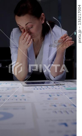 Stressed business woman suffering from headache in dark office, hands on head experiencing burnout and fatigue during late night work, facing deadline pressure and financial difficulties Stressed business woman suffering from headache in dark office, hands on head experiencing burnout and fatigue during late night work, facing deadline pressure and financial difficulties 138217004