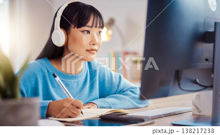 Candid documentary of a diverse Asian woman working on a laptop at home with natural light, capturing a real life remote work session and a healthy morning routine for a modern family lifestyle 138217238
